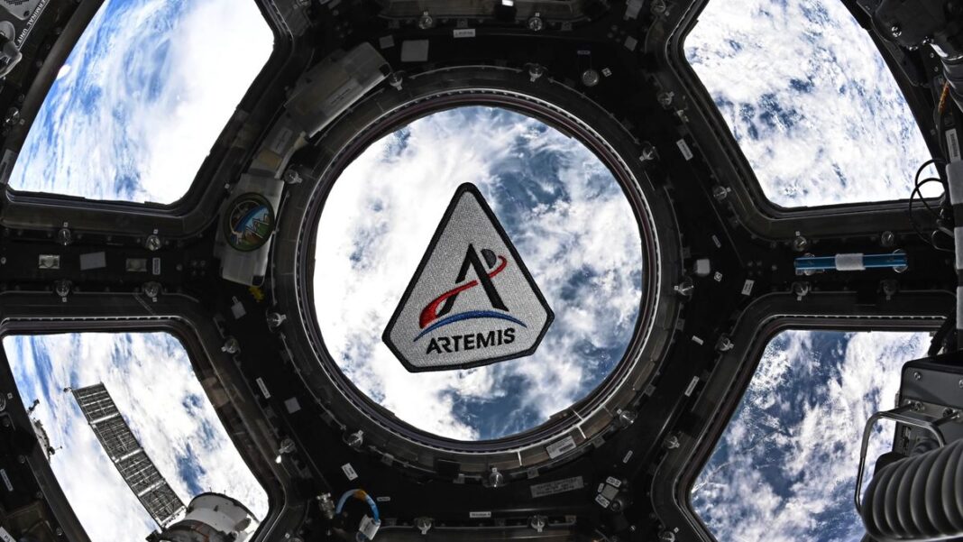 Ilustración de la nave Orión de la misión Artemis II en el espacio, con la Tierra y la Luna de fondo.