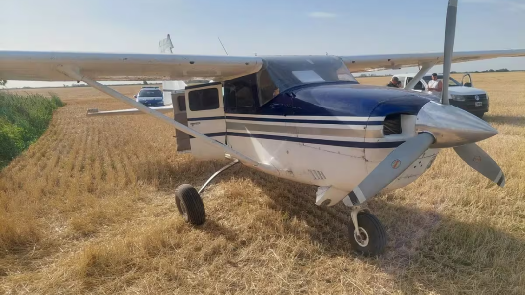Avioneta Cessna 206 similar a la incautada en un campo de Santa Fe, sobre fondo de hangar.