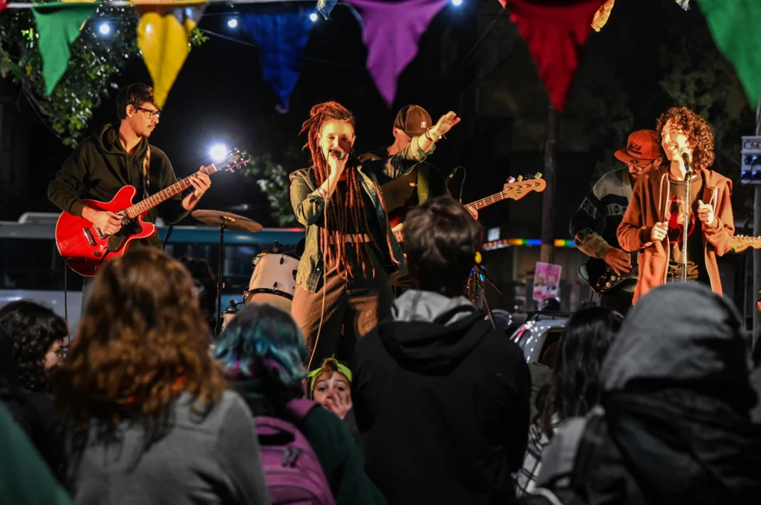 Personas disfrutando de una fiesta callejera con música y feria en el barrio Abasto de Santa Fe
