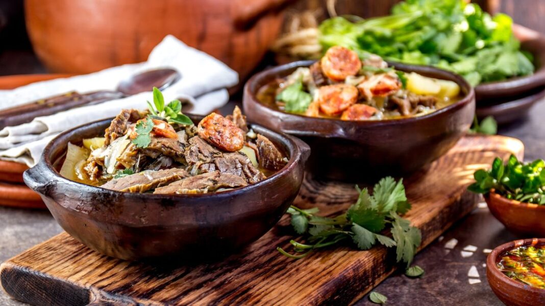 Variedad de platos tradicionales chilenos, incluyendo mariscos, cazuela y empanadas, sobre una mesa.