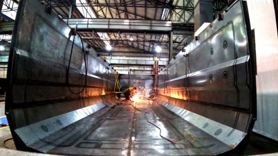 Gráfico de evolución de la actividad económica con flecha hacia abajo, superpuesto a un mapa de la provincia de Santa Fe.