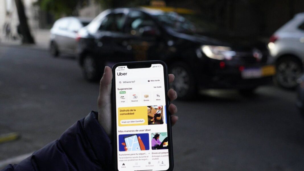 Conductor de Uber revisando el motor de su auto en un taller mecánico en Rosario