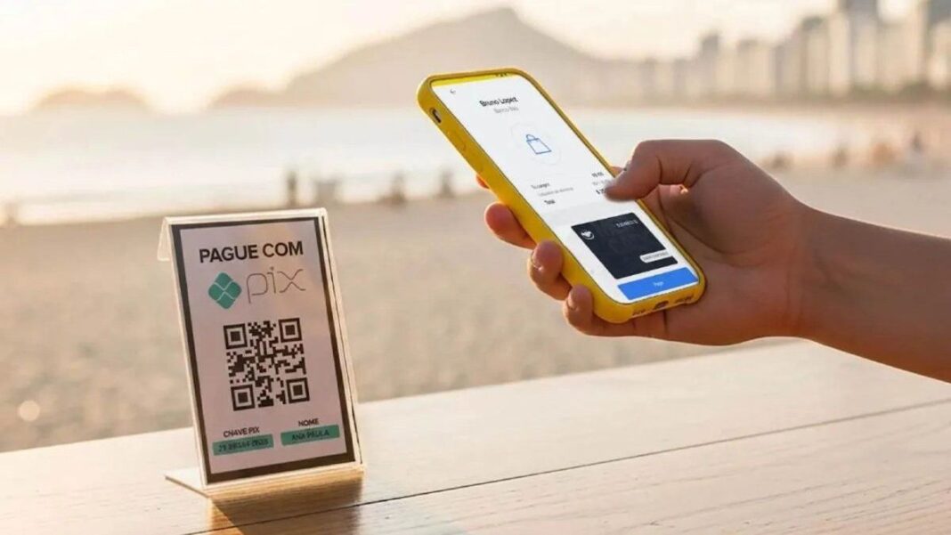 Persona usando teléfono móvil para pagar con PIX en una playa de Brasil