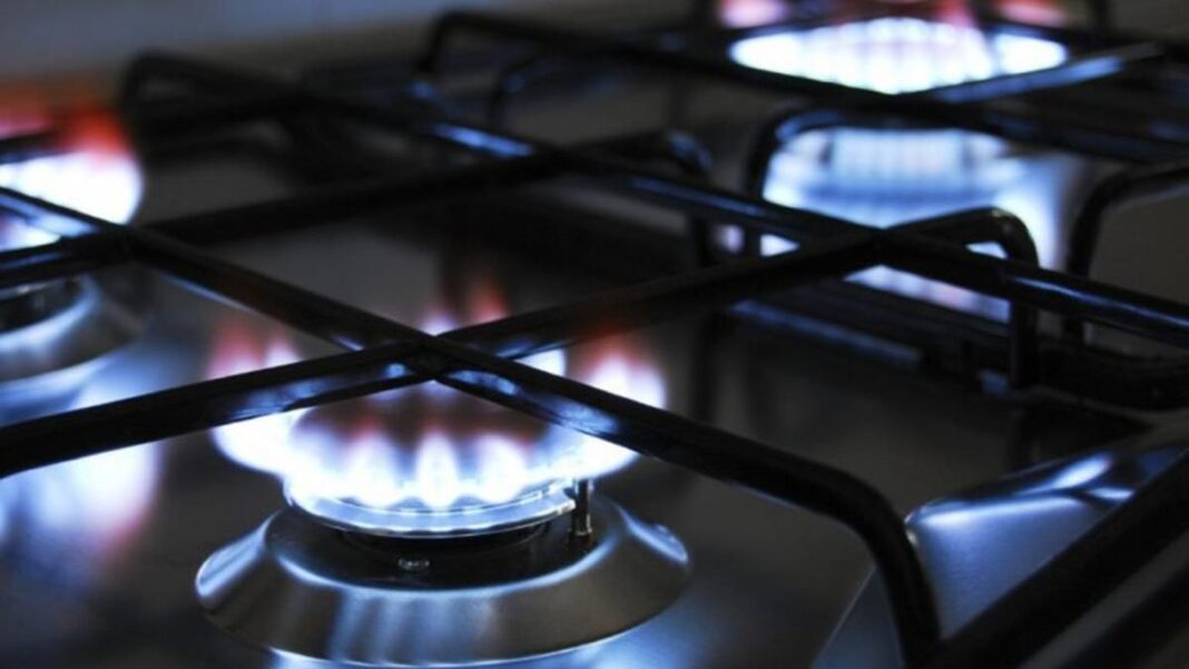 Medidor de gas natural con billetes y monedas al lado, simbolizando el recorte de descuentos en la tarifa