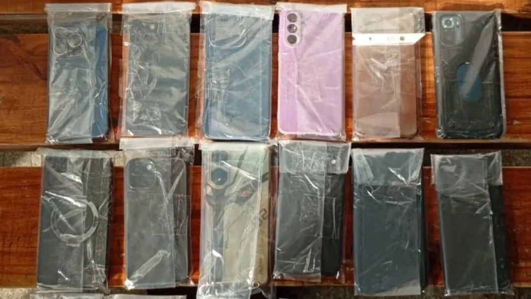 Efectivos policiales revisan celulares recuperados en un operativo en Rosario