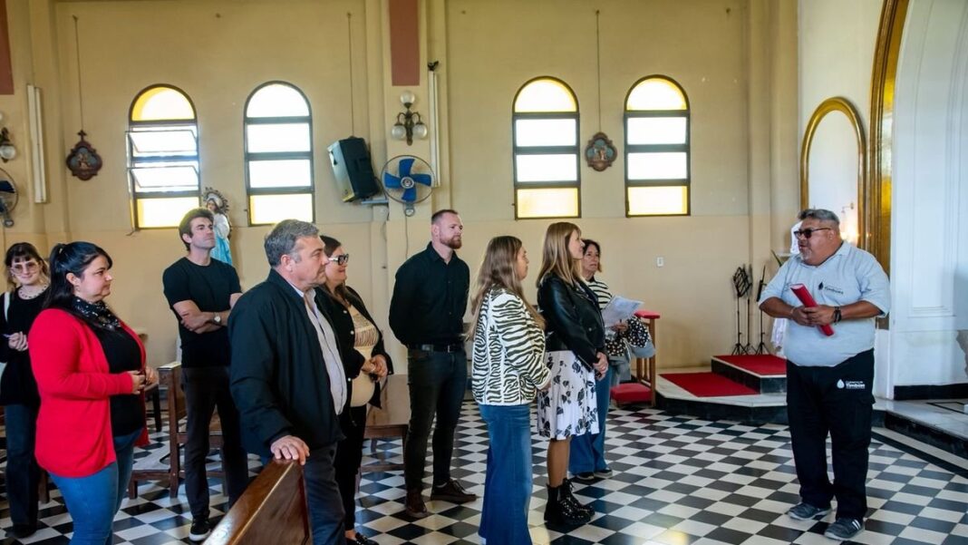 Guía turístico explicando detalles históricos frente a un edificio antiguo en Timbúes