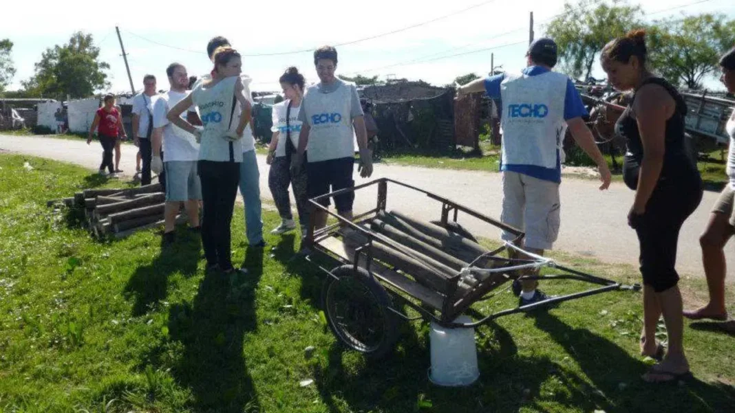 Voluntarios construyendo vivienda modular de TECHO en barrio Piamonte, Rosario