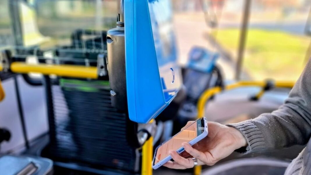 Persona usando tarjeta SUBE en validadora de colectivo