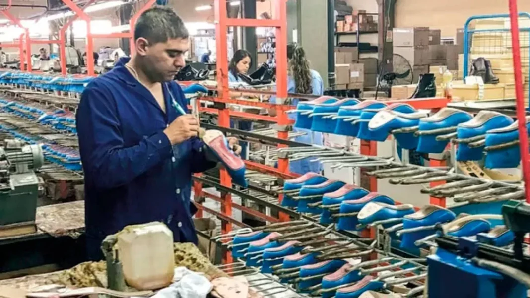 Fábrica de calzado con operarios trabajando en la línea de producción